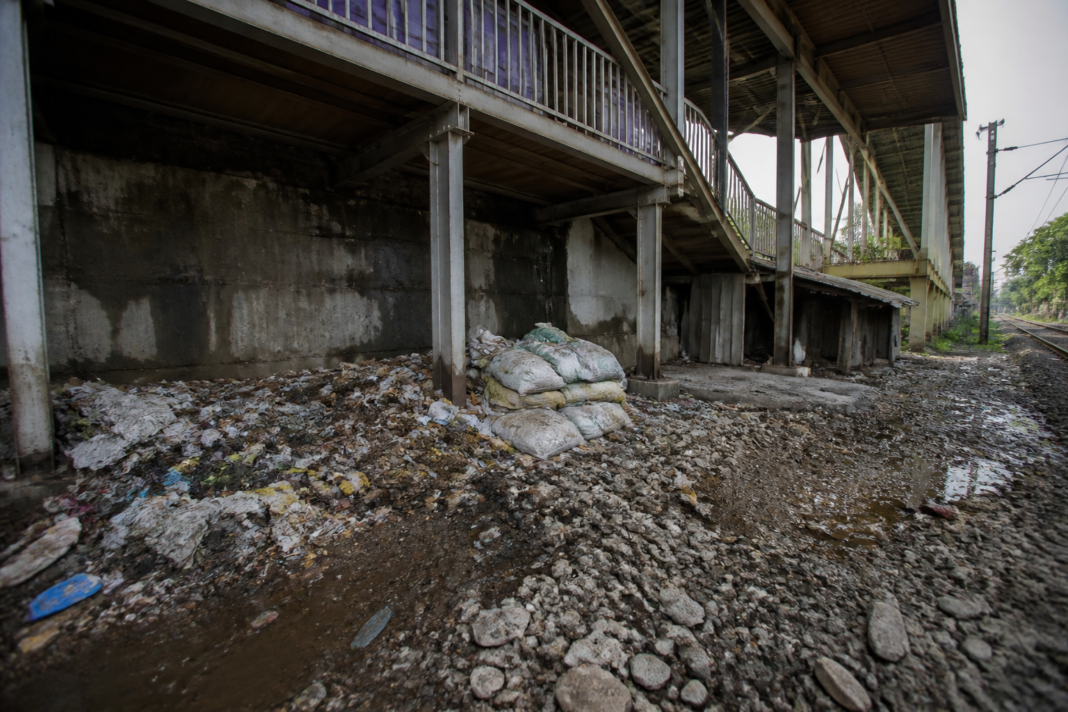 Waste and construction debris accumulated beneath a pedestrian bridge at Dombivli railway station