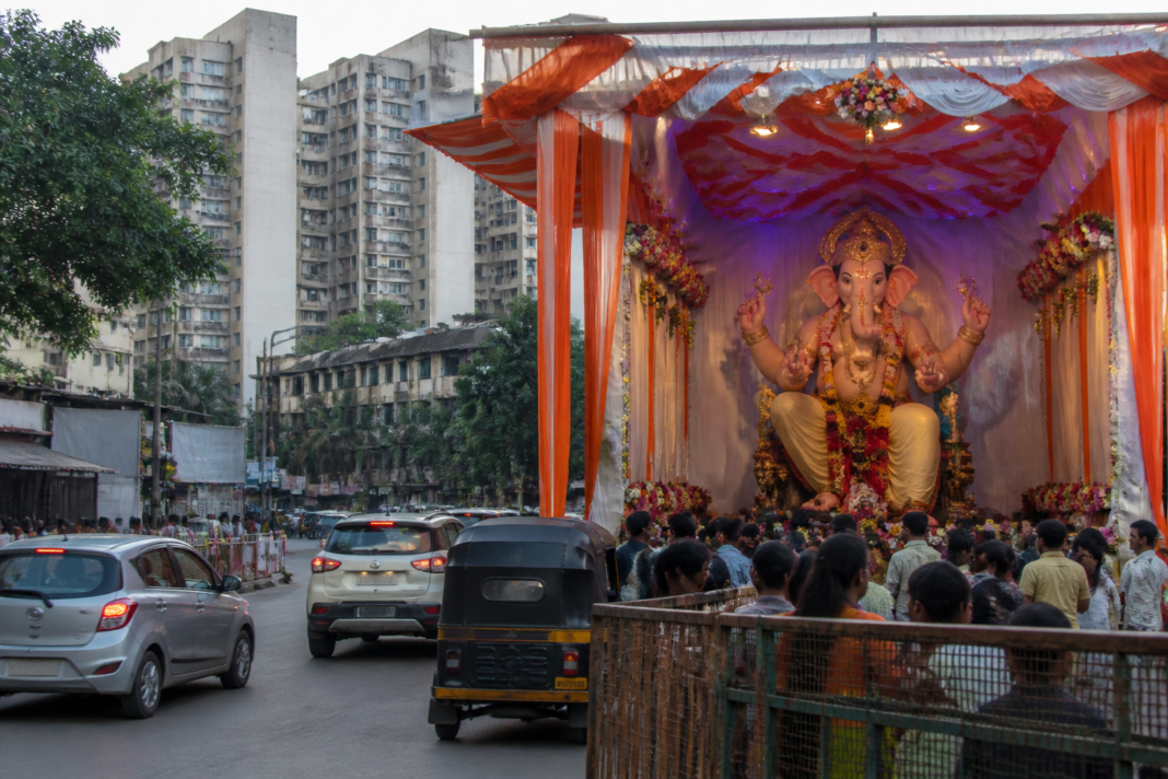 Ganeshotsav mandap occupying part of a road in Mira Bhayandar, with traffic passing through the remaining space