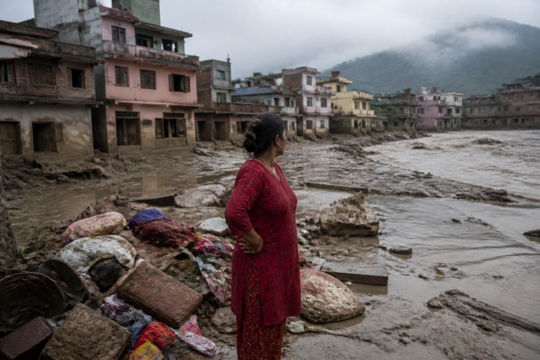 Flood-damaged homes and debris in Nepal after flash flooding, illustrating the insurance challenges facing displaced households