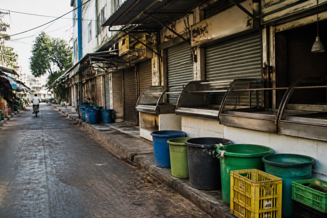 Chicken vendors and waste containers outside a Bengaluru poultry shop during a protest over the Bengaluru chicken waste tax