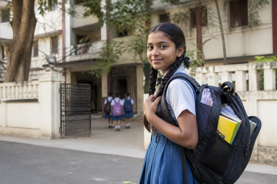 Student carrying a schoolbag outside a Maharashtra school, illustrating the state's 10% schoolbag weight limit