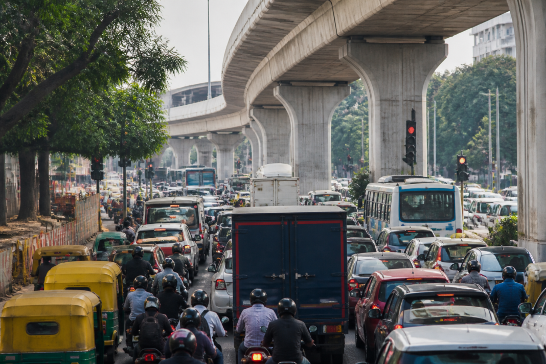 Traffic moving along a congested surface road below an elevated flyover in Bengaluru amid flyover restrictions