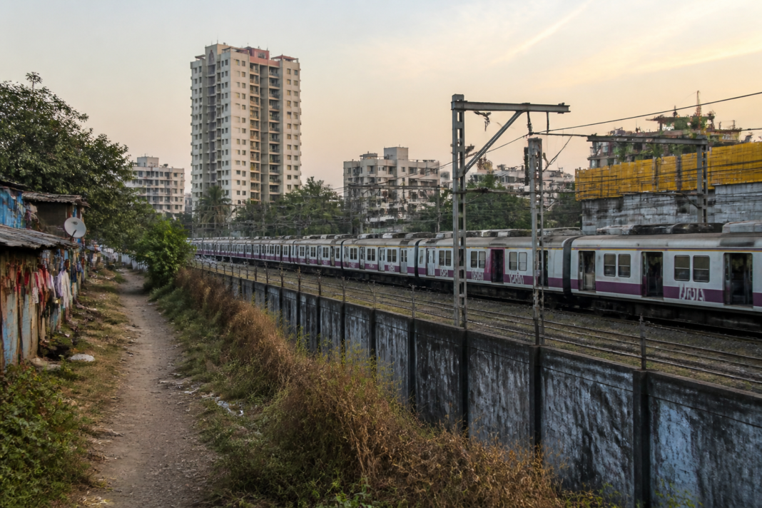 Parked local trains inside a secured railway yard near Thakurli, illustrating railway safety risks around residential areas