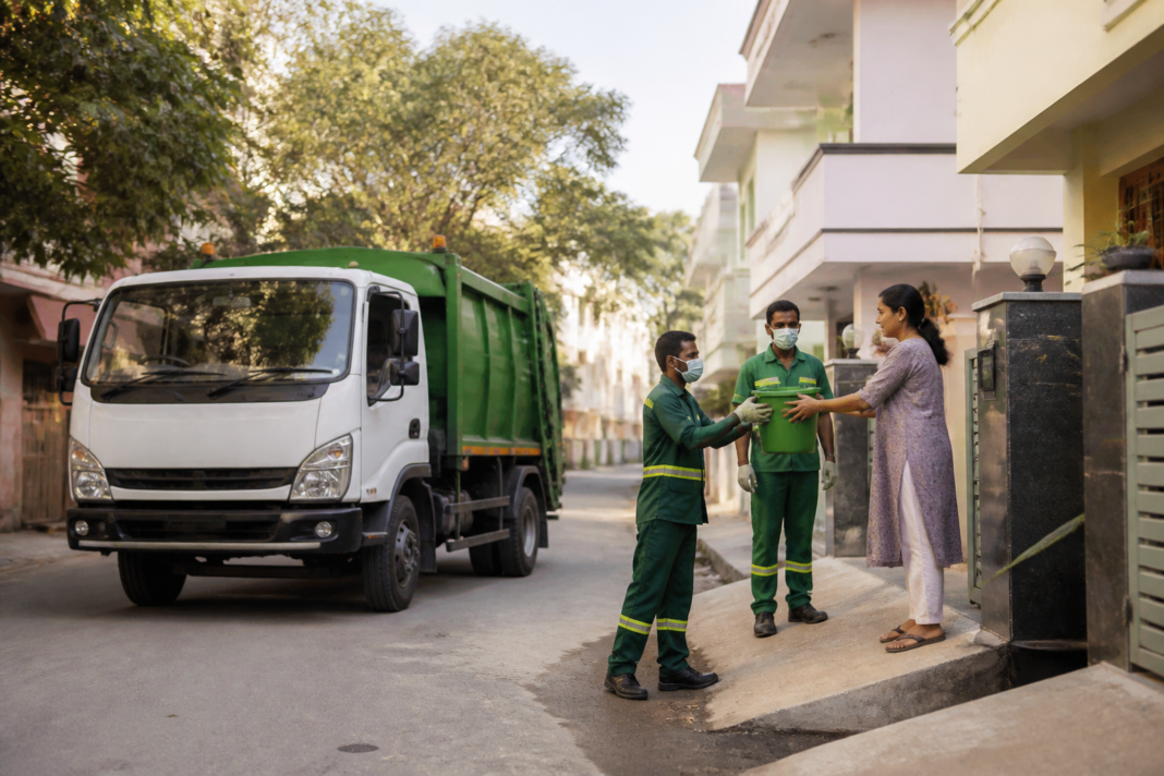 GPS-enabled waste collection vehicle operating on a Bengaluru residential street