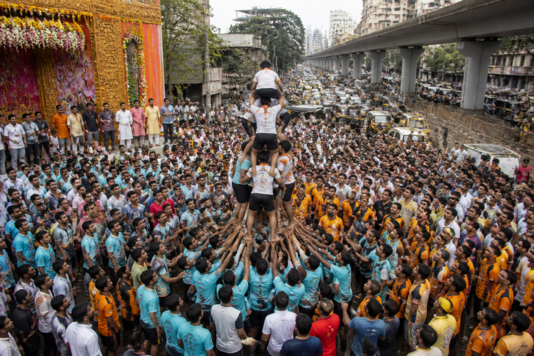 Govinda teams gather on a traffic-diverted road during Thane Dahi Handi celebrations