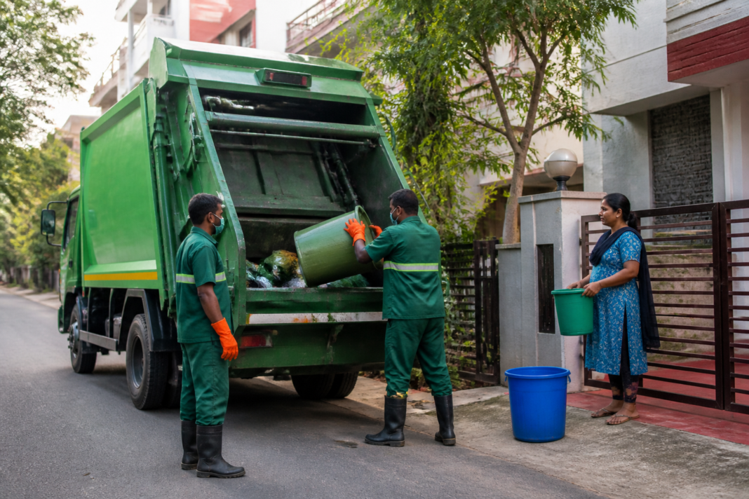 Waste collection vehicle operating on a Bengaluru residential street as the city prepares a new GPS-monitored doorstep collection system