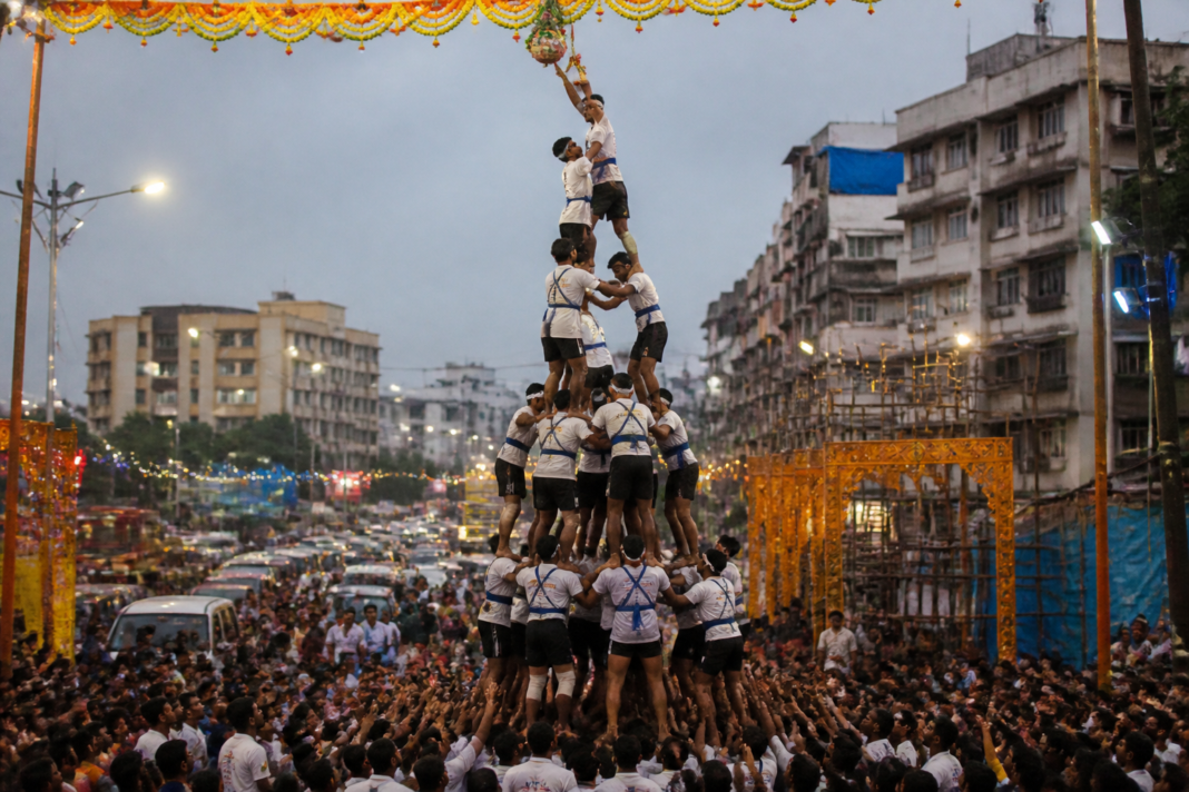 Govinda participants forming a human pyramid during a crowded Vasai Virar Dahi Handi celebration