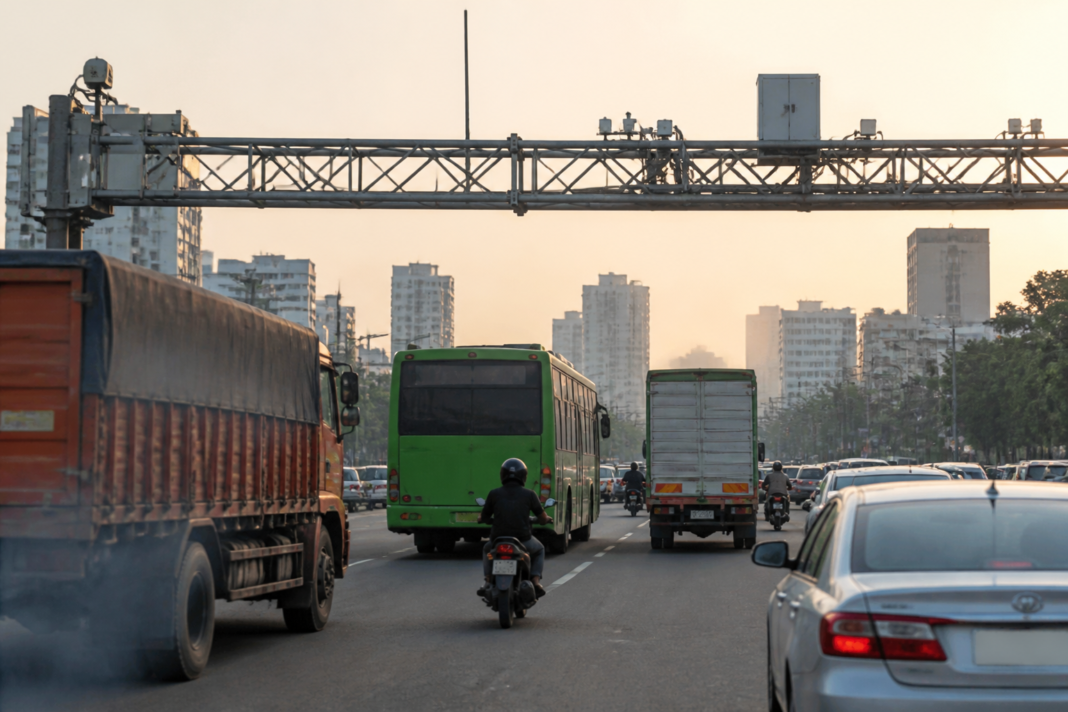 Commercial vehicles and passenger cars on an Indian urban road, illustrating BS7 emission norms and vehicle emissions-control technology