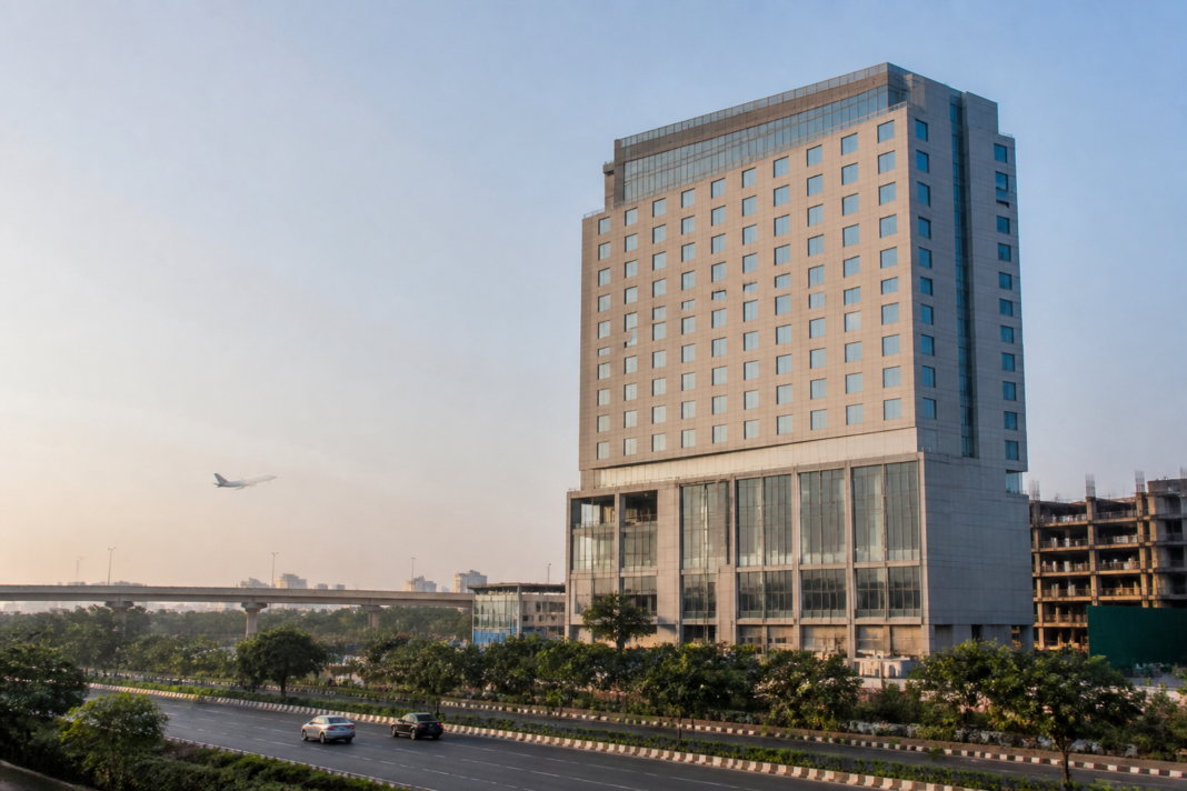 Urban hotel development representing Chalet Hotels expansion, with a modern hospitality tower beside a busy Indian city district
