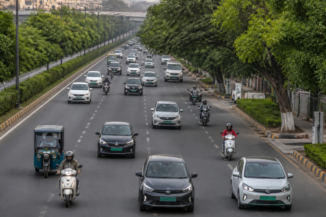Alternative fuel vehicles in India represented by electric cars, CNG vehicles and urban traffic on a city road