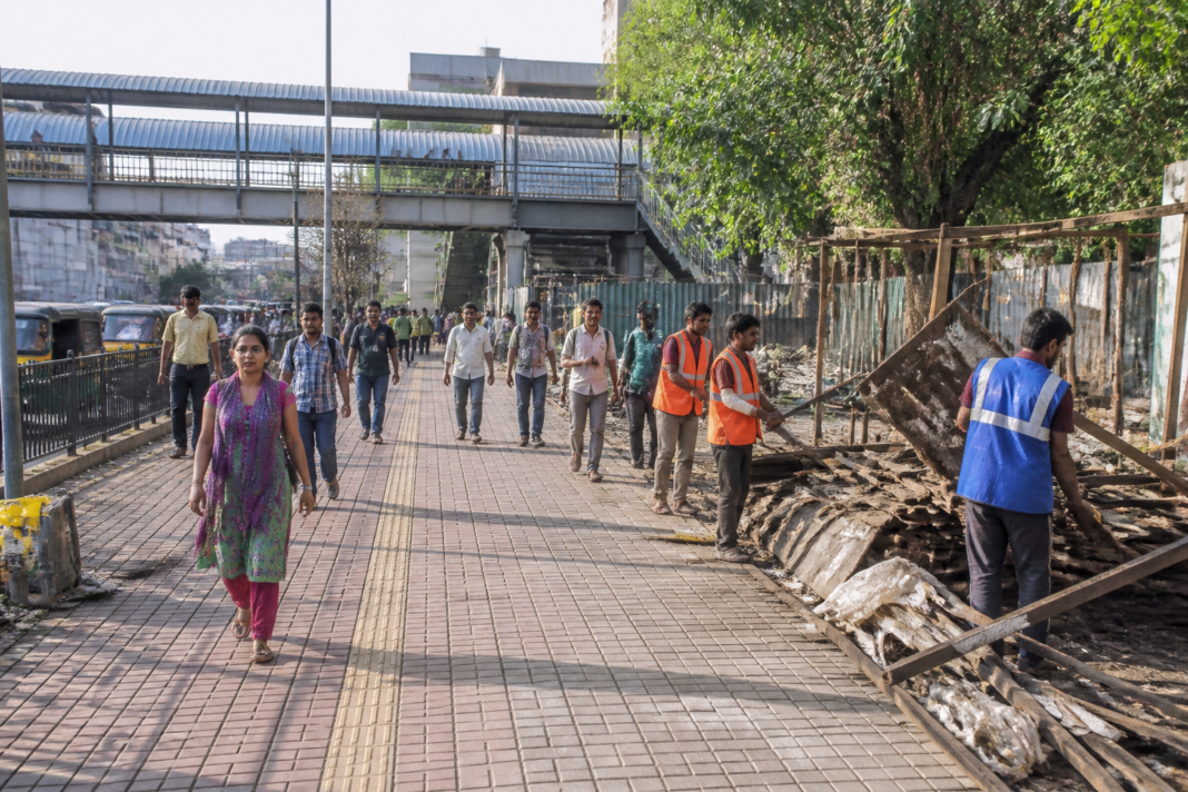 Municipal workers clearing an encroached footpath near a railway station in Navi Mumbai