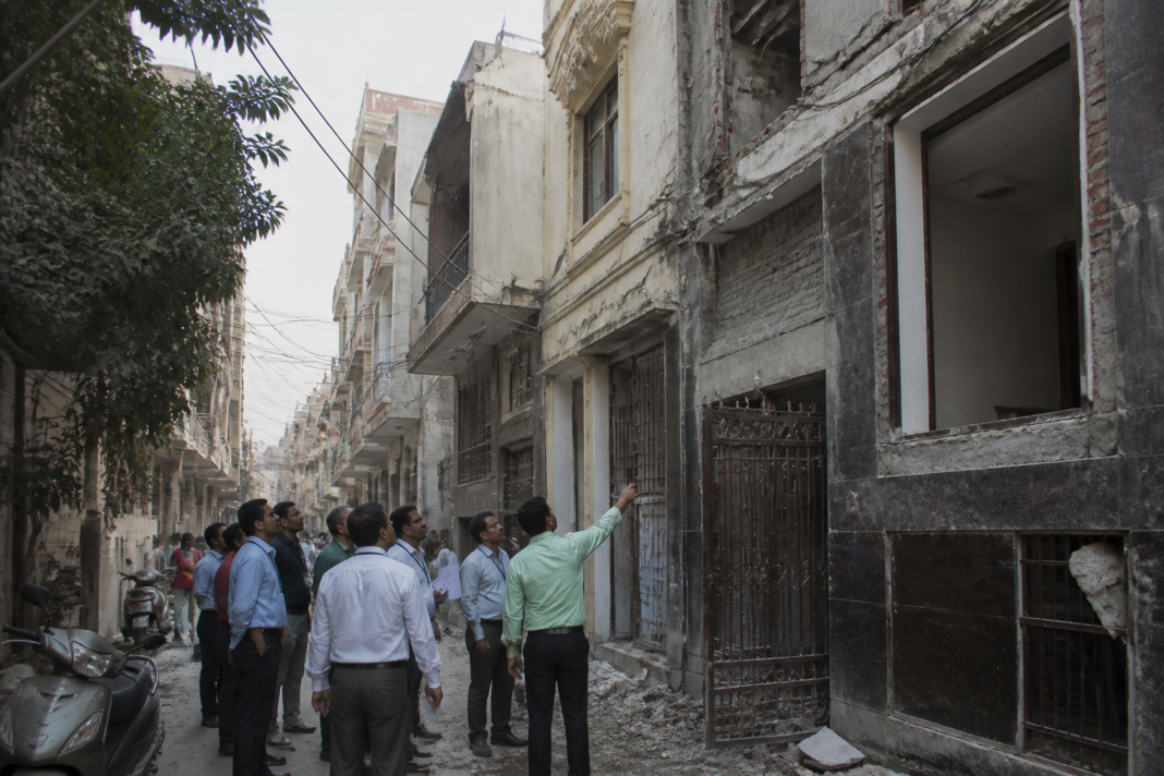 Delhi building safety inspection near a dense urban property with visible construction activity