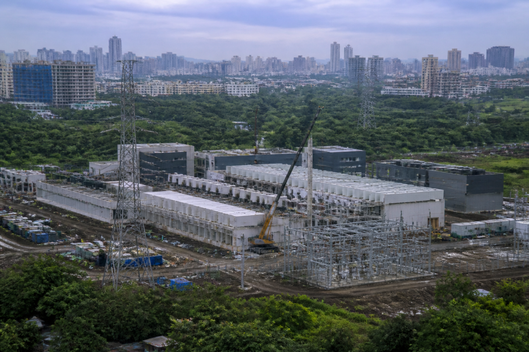 Mumbai data centres rising along an urban industrial corridor with power infrastructure and high-voltage lines