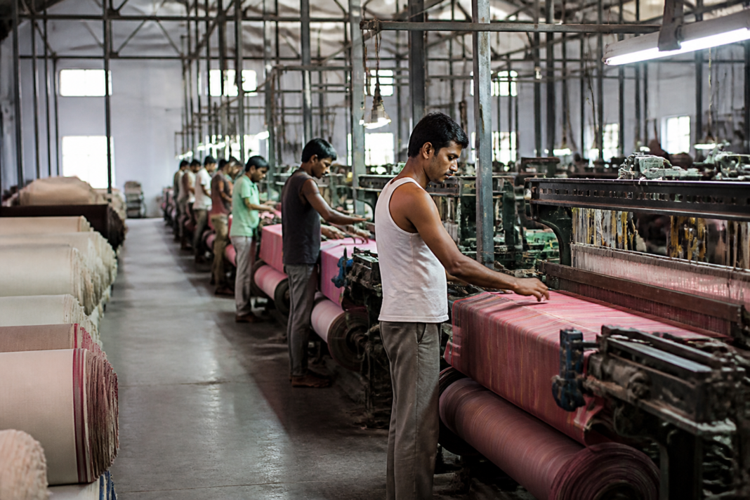 Textile workers operating powerlooms in a Maharashtra textile manufacturing unit