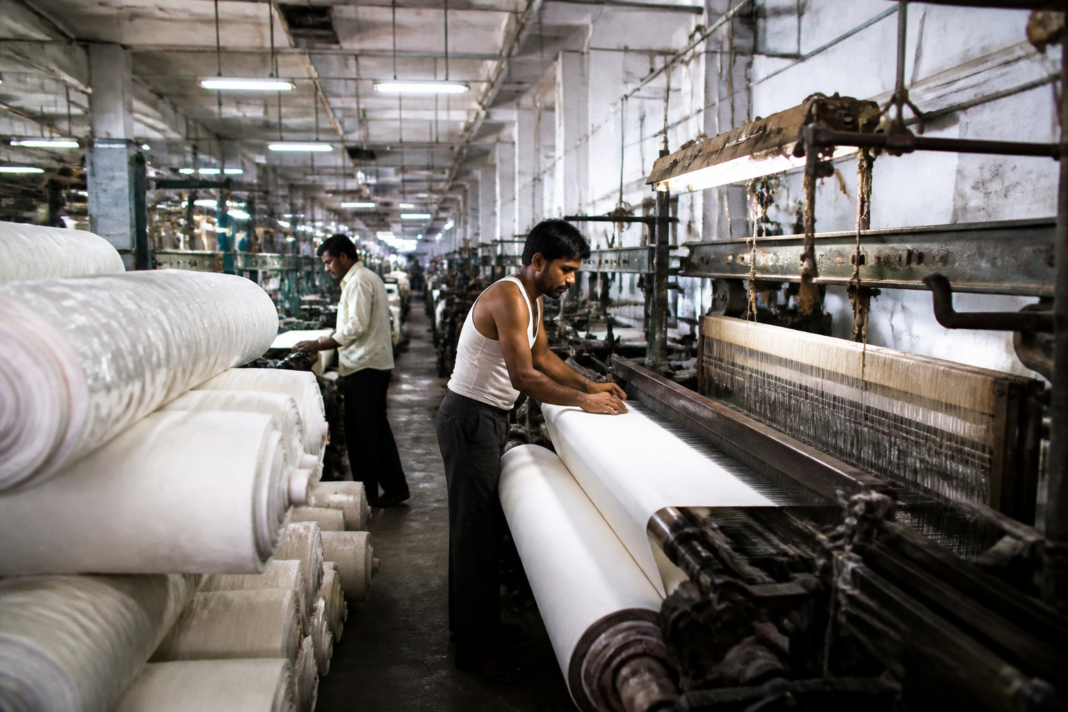 Textile workers and powerloom machinery inside a Maharashtra textile facility