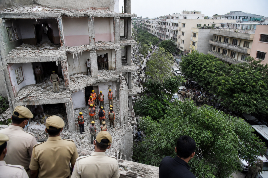 Police and rescue personnel at the site of the Satya Niketan building collapse in New Delhi