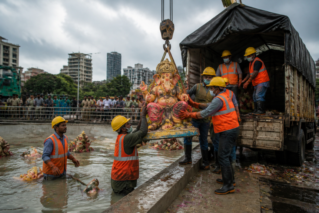 POP Ganesh idols Mumbai being collected after immersion for covered transport and recycling.