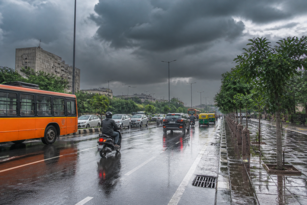 Delhi weather forecast showing rain over a city road during the monsoon