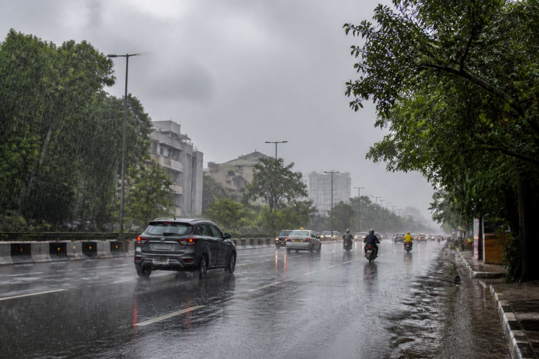 Telangana rainfall over a city road under dark monsoon clouds