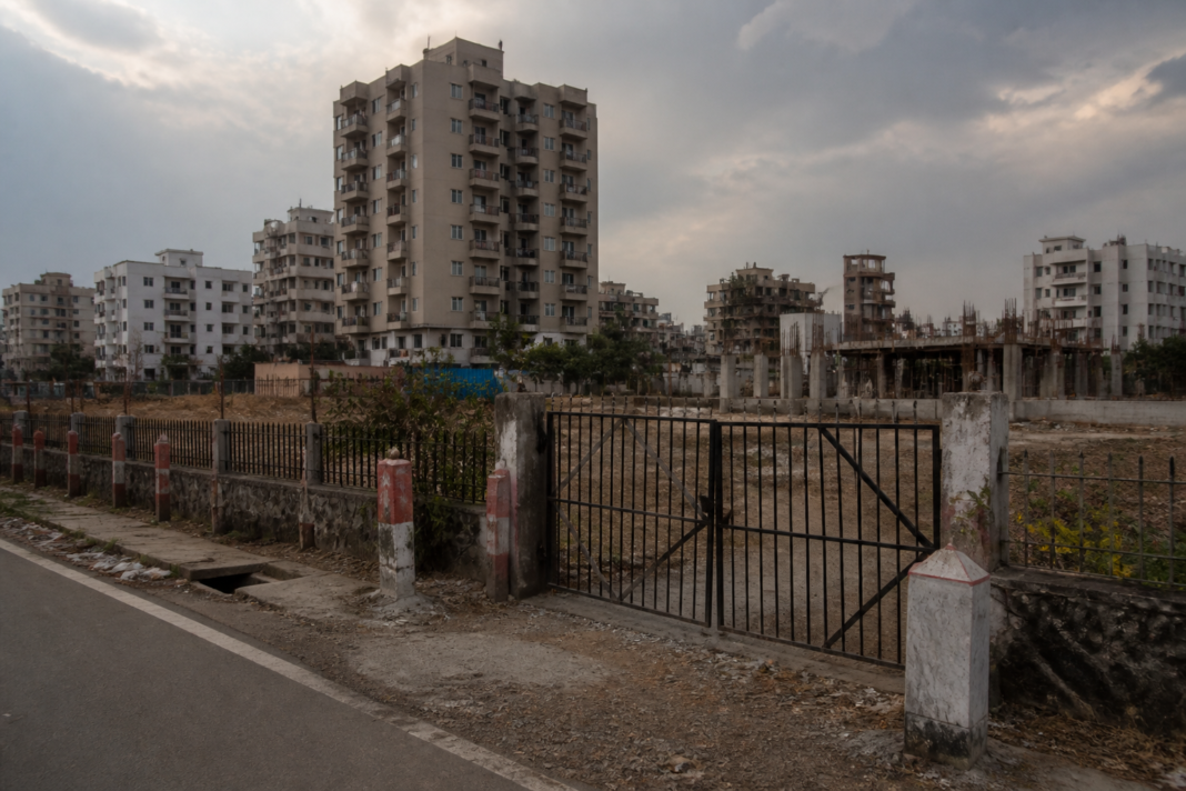 Bhayander land dispute site near Navghar in Mira Road with urban construction in the background