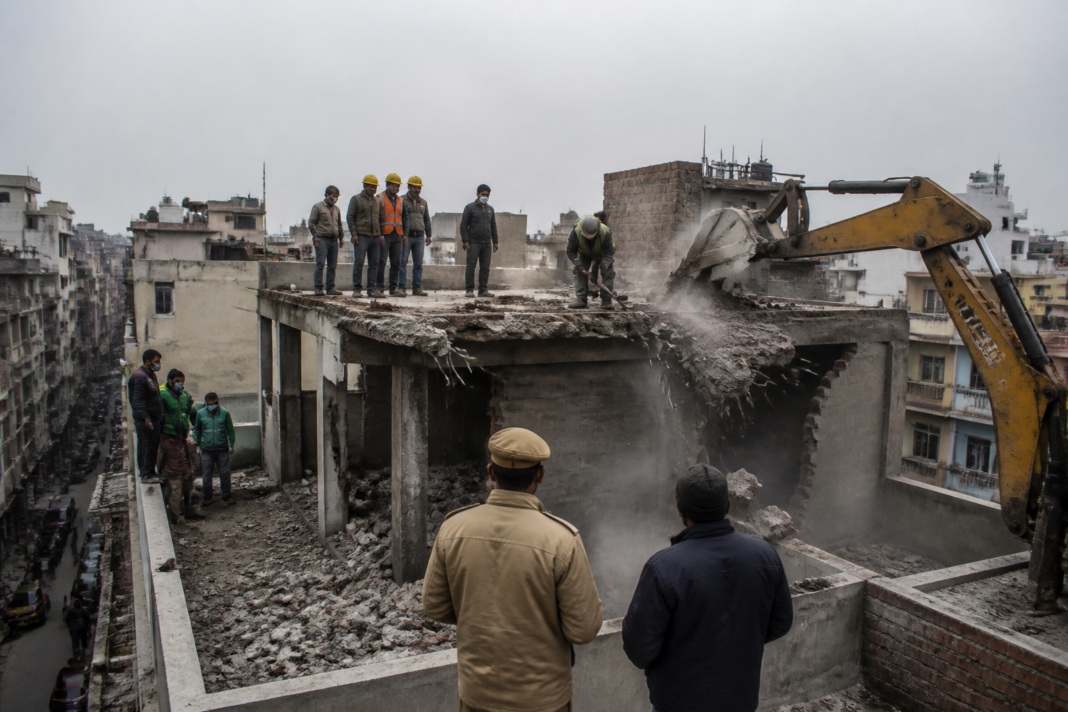 Delhi MCD demolition team removing an unauthorised rooftop structure during an enforcement drive