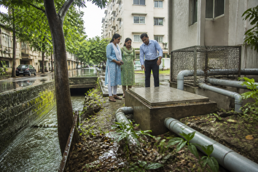 Chennai rainwater harvesting system beside an urban building during monsoon conditions