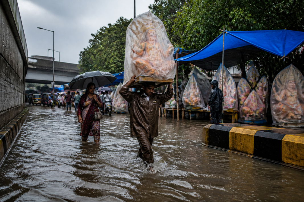 Mumbai heavy rain flooding a low-lying road near Ganeshotsav decorations.