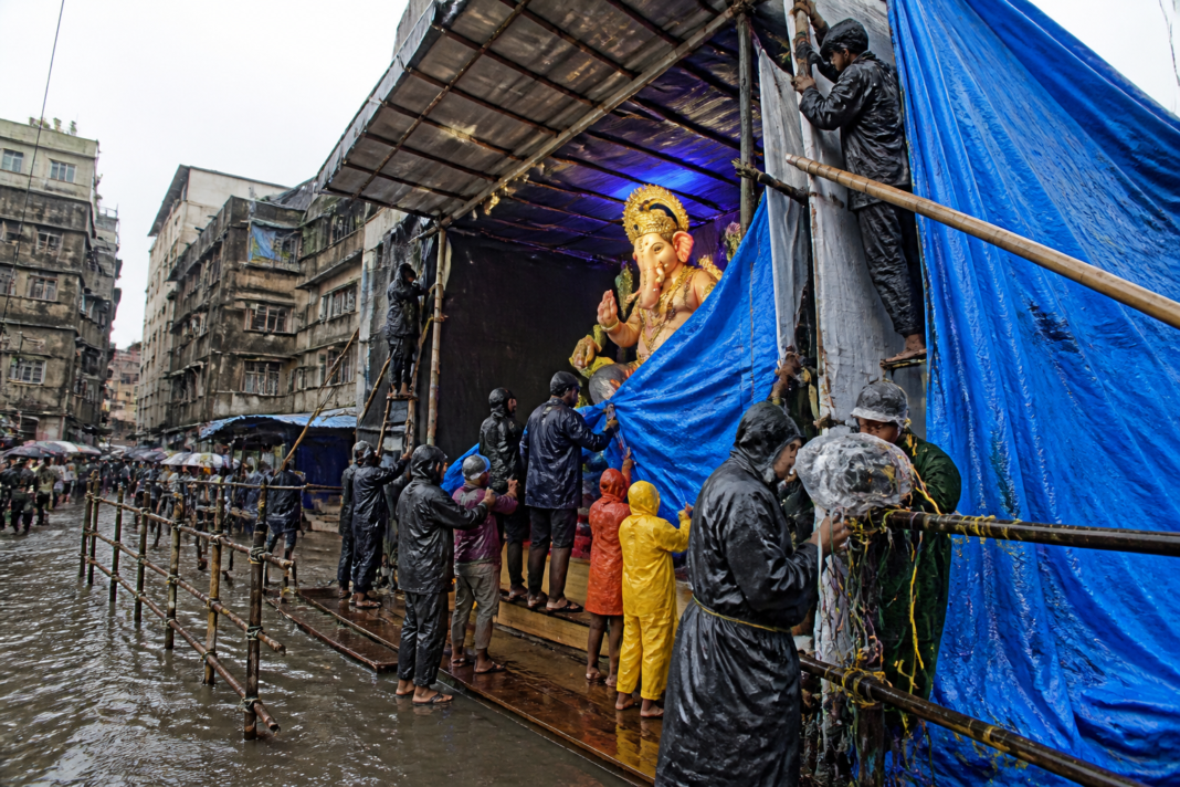 Mumbai Ganeshotsav rain affecting a covered Ganpati pandal and waterlogged visitor area