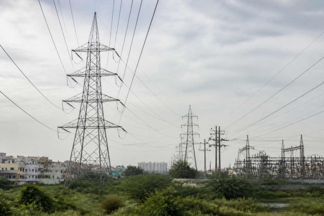 Tamil Nadu power supply infrastructure with electricity transmission towers under an overcast sky