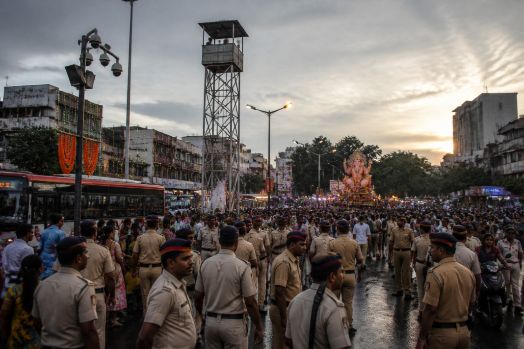 Pune Ganeshotsav security personnel monitoring a crowded city junction with surveillance cameras