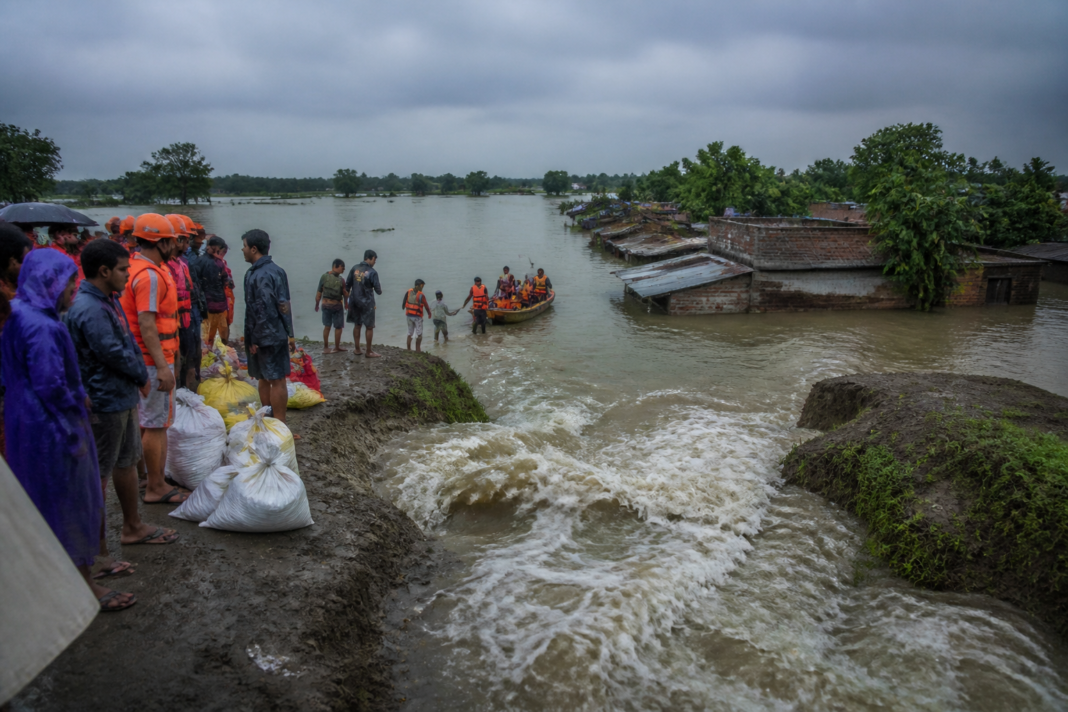 Bhutni embankment breach amid flooding in Malda, with inundated homes and rescue supplies