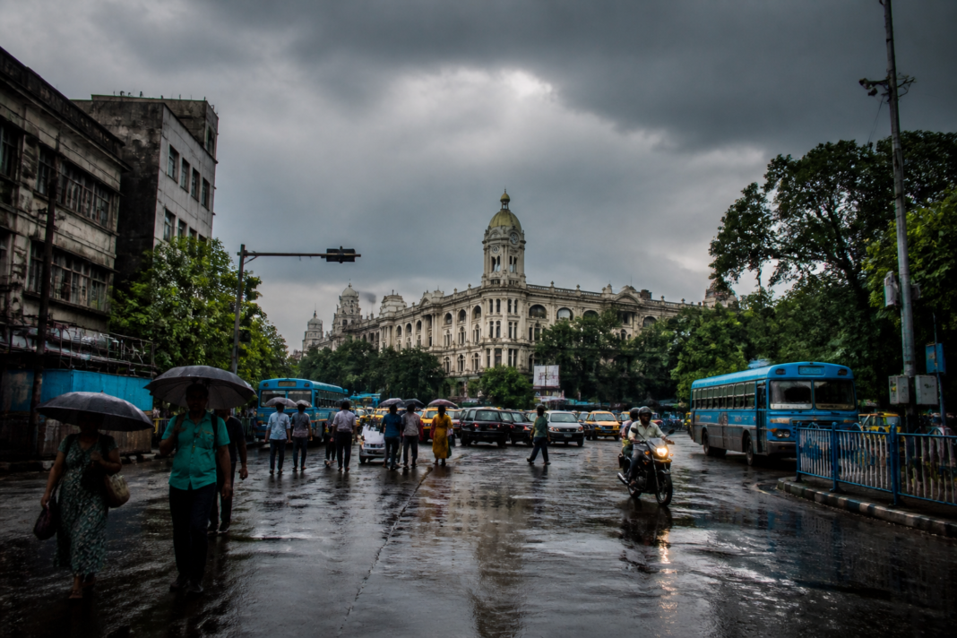 Kolkata weather forecast during monsoon rain with commuters and wet city streets