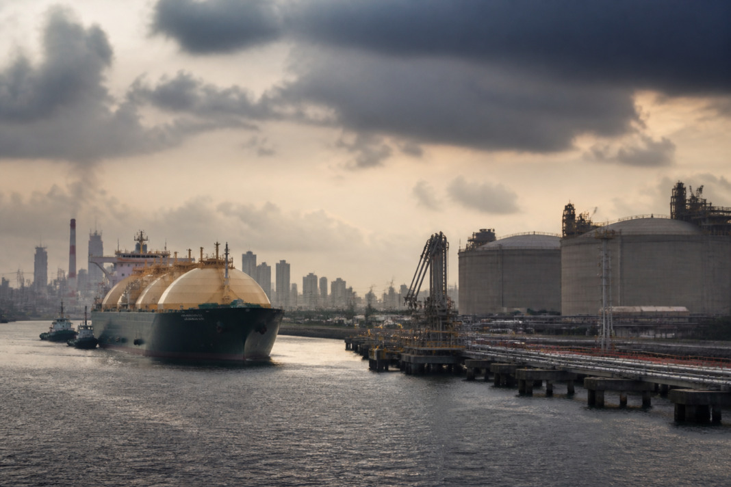 India LNG tanker and coastal energy infrastructure under a tense overcast sky