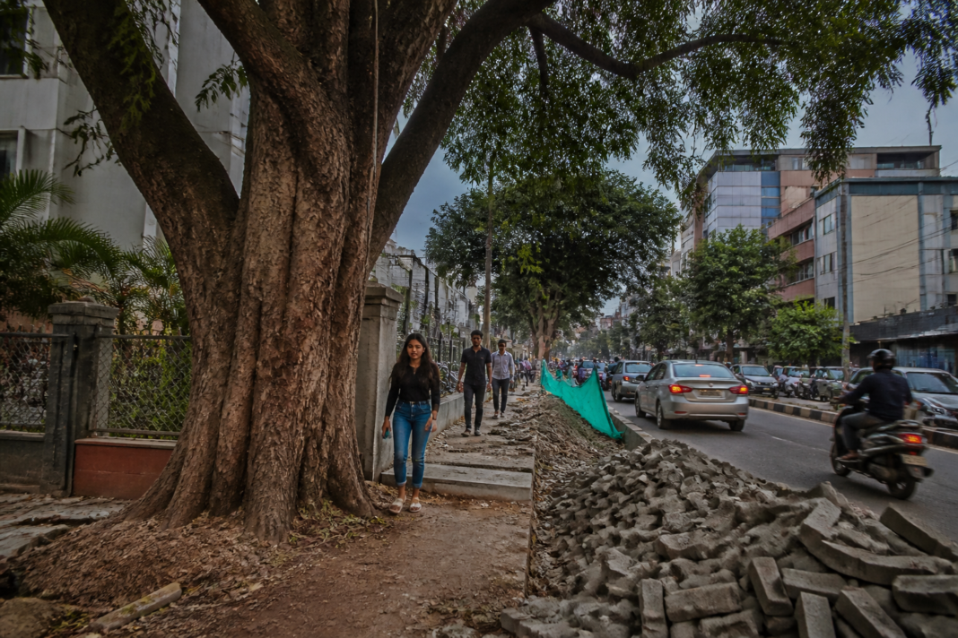 Bengaluru tree cutting beside a construction site and blocked footpath in an urban neighbourhood