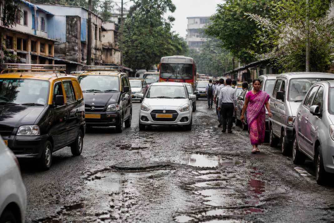 Mumbai civic issues on a congested road with potholes, traffic and obstructed public space