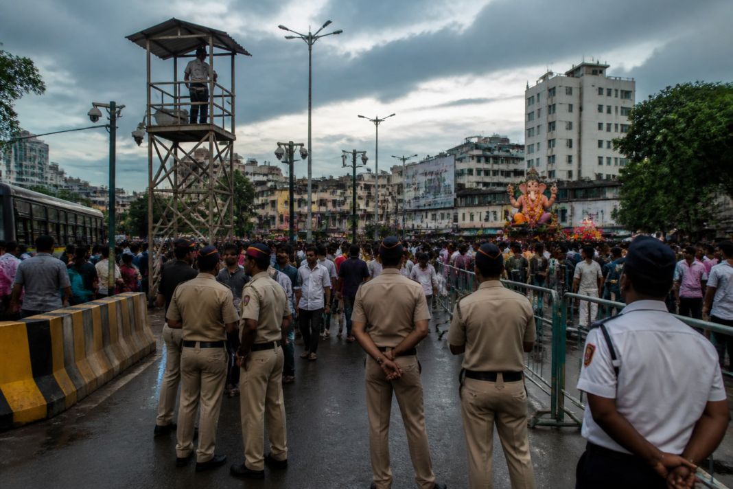 Pune Ganeshotsav security personnel monitoring crowds near a busy city junction