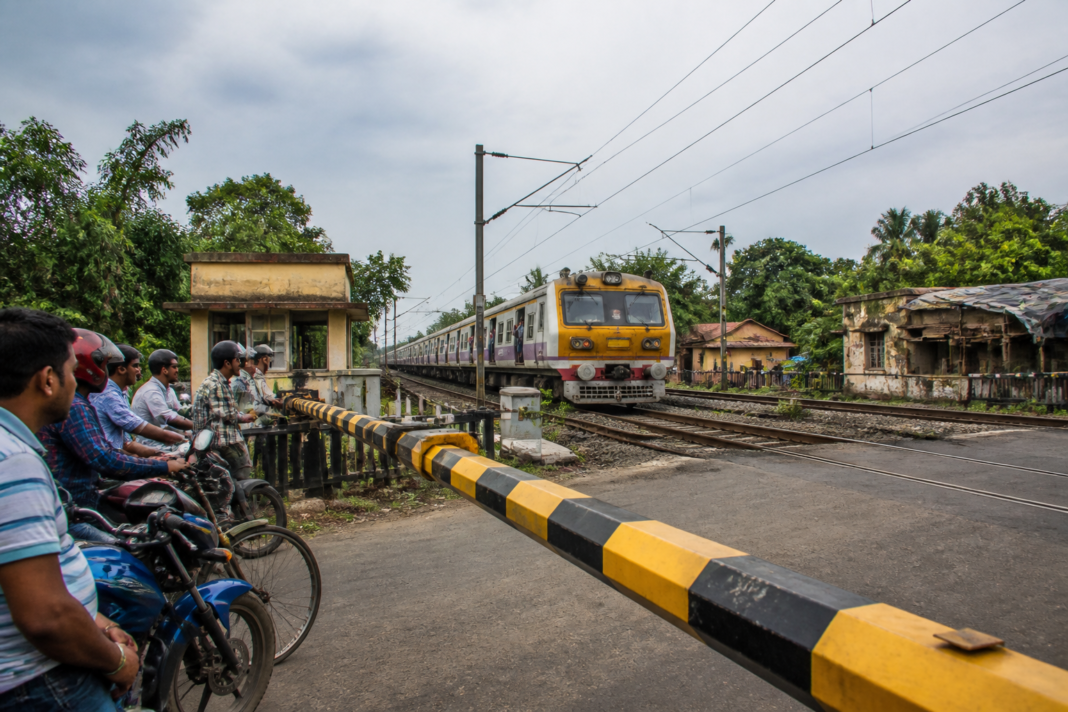 Somra railway gate near Hooghly with a local train approaching the level crossing