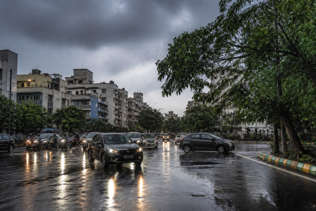 Karnataka rains over a Bengaluru neighbourhood with wet roads and dark monsoon clouds