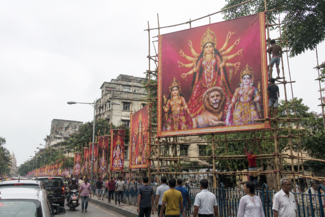 Kolkata Puja hoardings mounted on temporary bamboo frames along a city street
