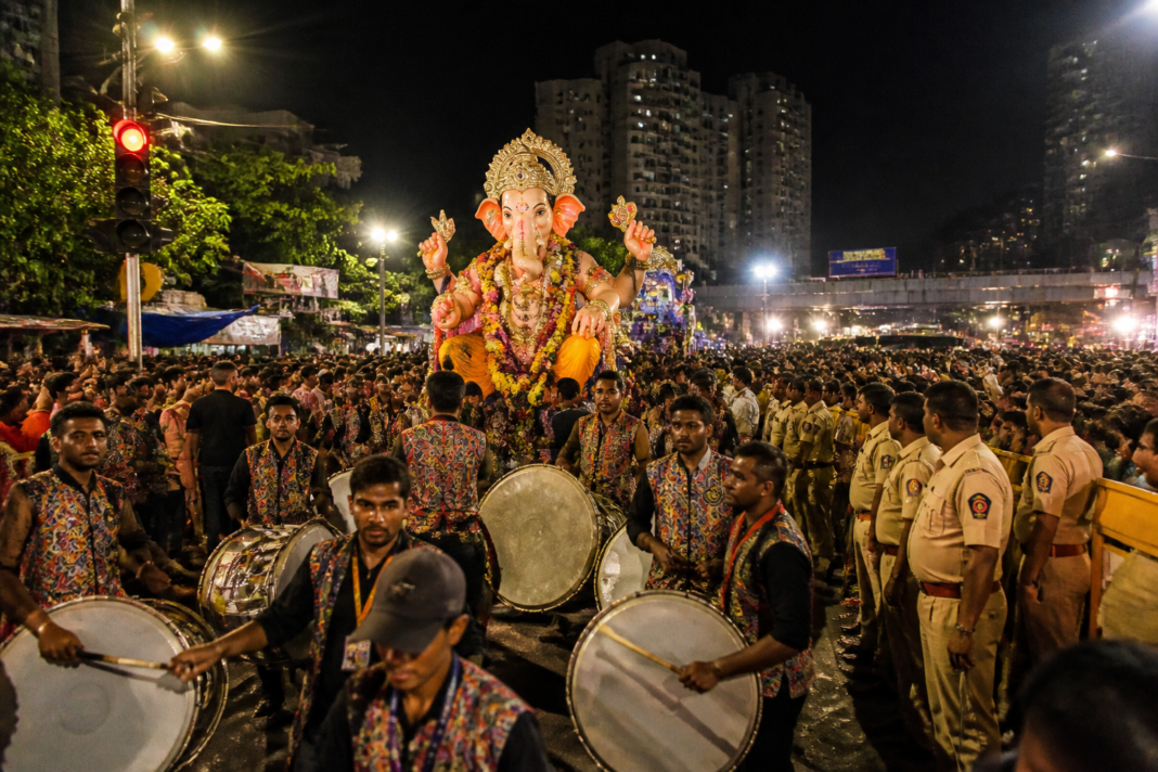 Thane Ganpati visarjan procession near an immersion site with drums and crowds at night