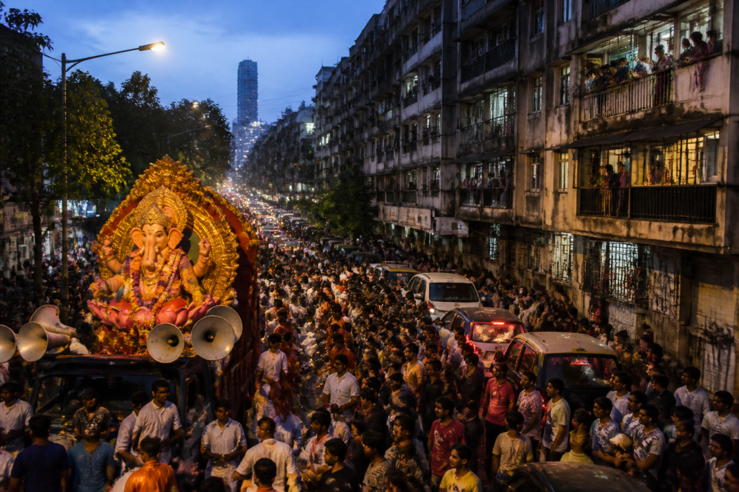Mumbai Ganeshotsav procession with loudspeakers and residents near a residential street