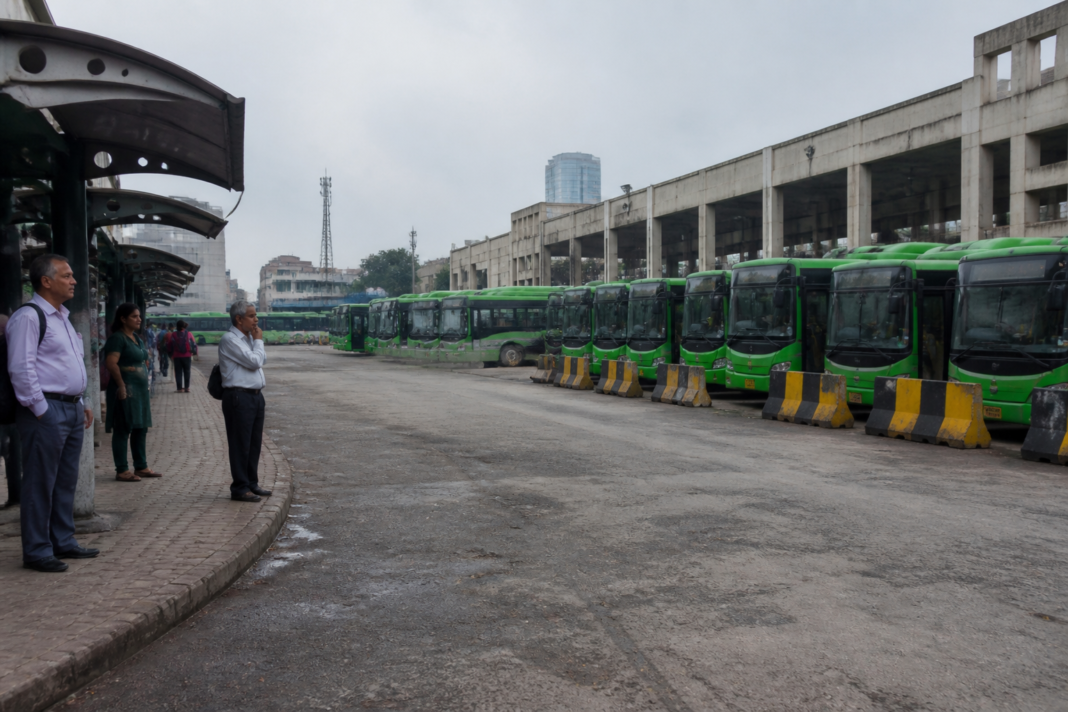 Delhi DTC bus strike leaves buses parked at a depot as commuters seek alternate transport.