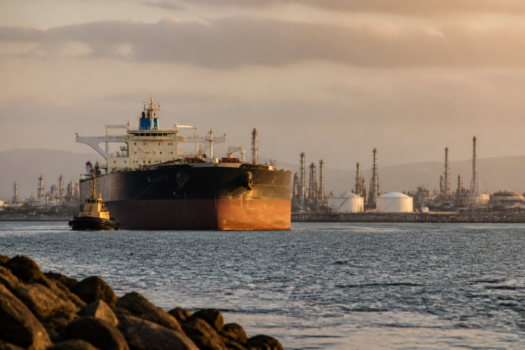 Russian crude oil tankers near an Indian refinery, highlighting India’s energy dependence and trade risk.