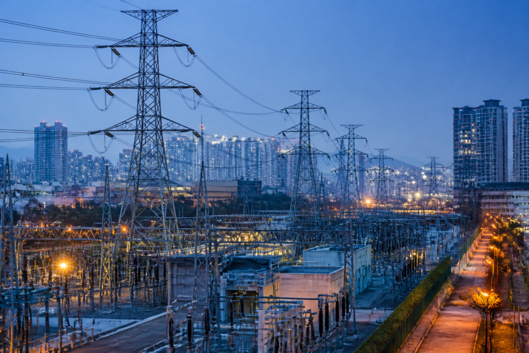 Electrification infrastructure with transmission lines and an Asian city skyline