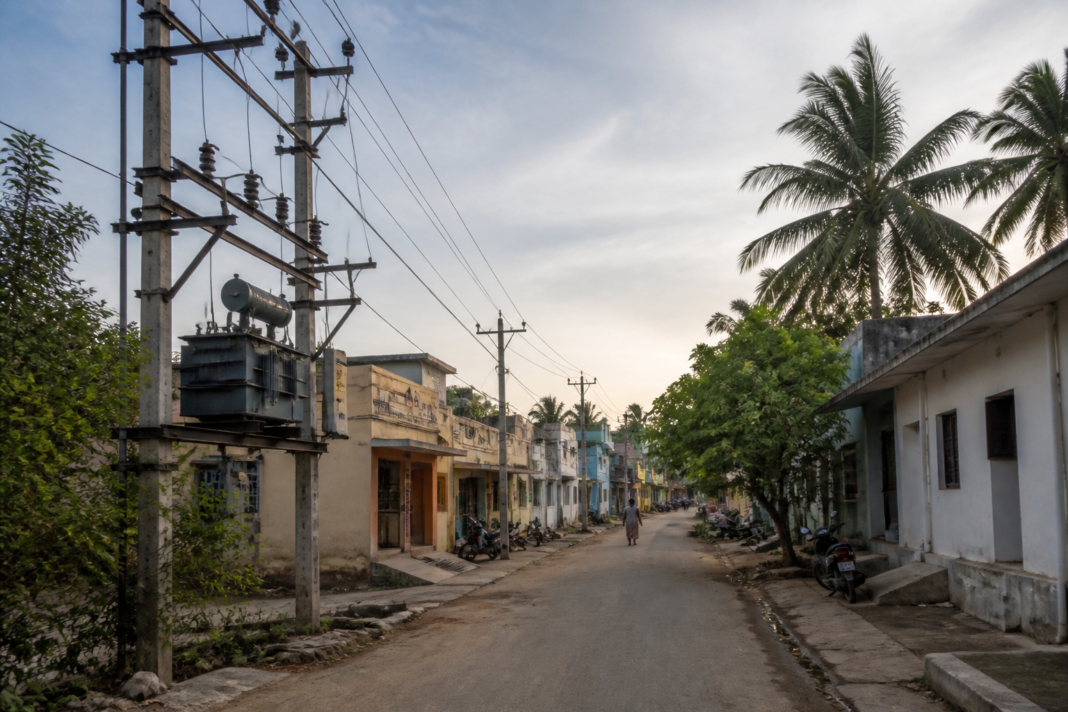 Electricity poles and homes representing power connections for eligible poromboke land houses in Tamil Nadu
