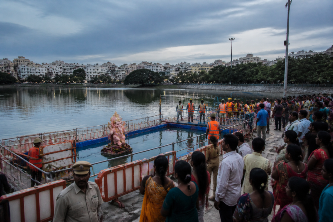 Ganesh immersion safety arrangements at a Hyderabad lake with barricades and warning signs