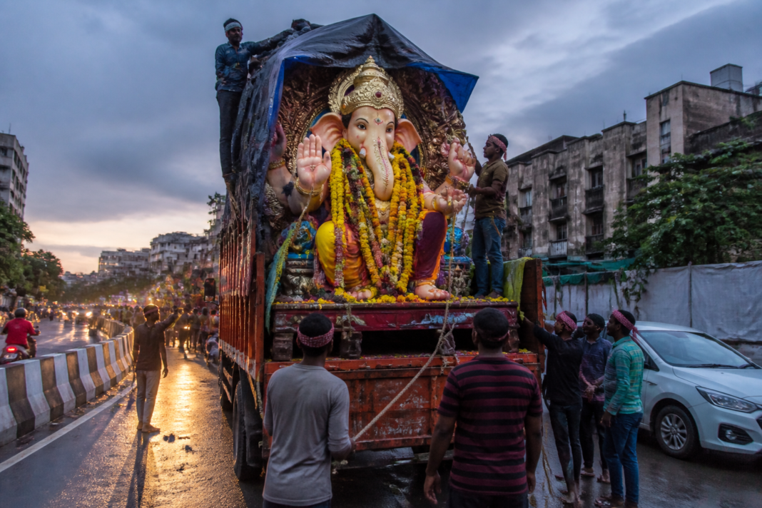 Hyderabad Ganesh festival business activity with an idol transport truck on a city road