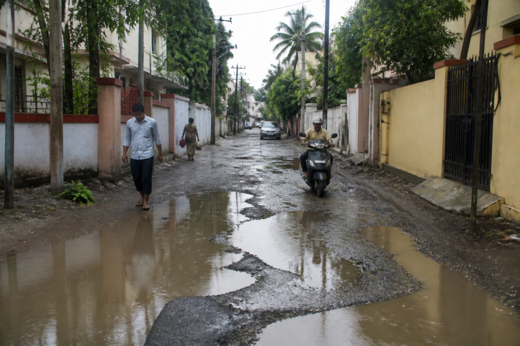 Damaged Iyyappanthangal road in VGN Nagar with potholes, gravel and stagnant rainwater