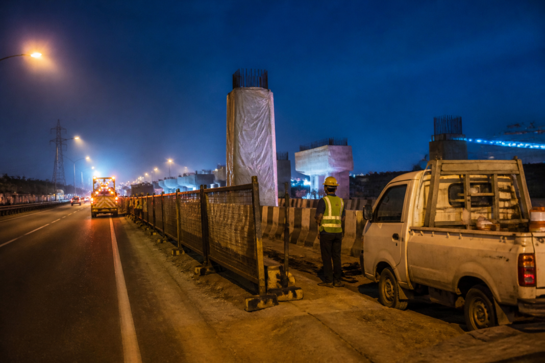 Dwarka Expressway crash worksite with roadside barriers and construction equipment at night