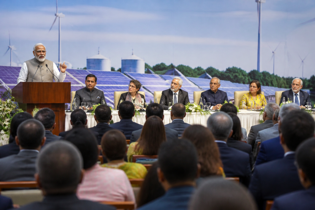 India climate emissions debate at an environment conference with a renewable energy visual backdrop